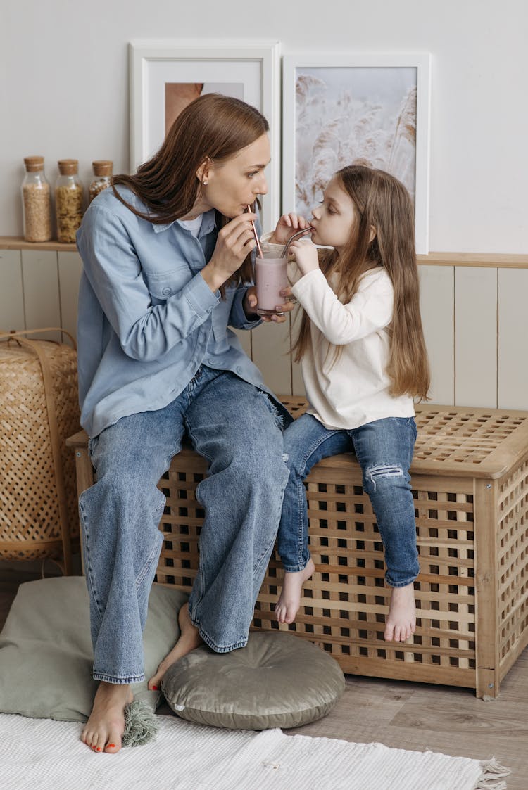 A Daughter And Her Mother Drinking With Straws