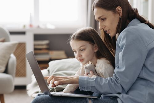 Free Mother and daughter enjoying quality time using a laptop together indoors. Stock Photo