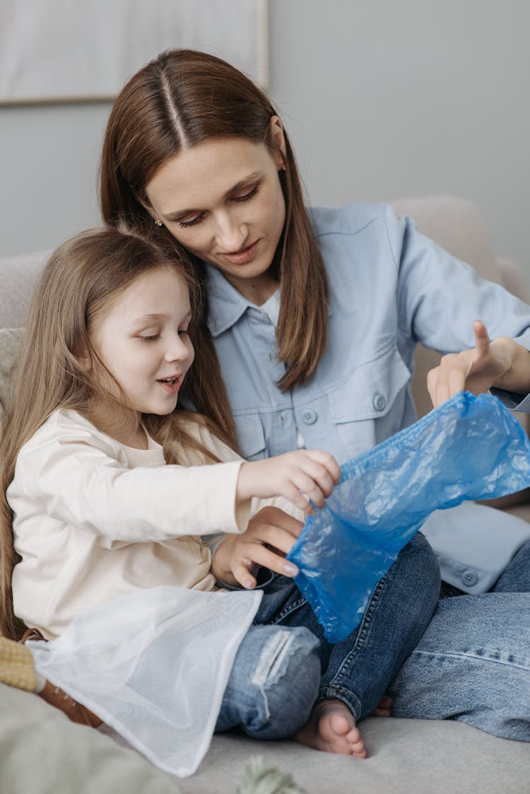 Mother And Child Holding A Blue Plastic Shoe Cover