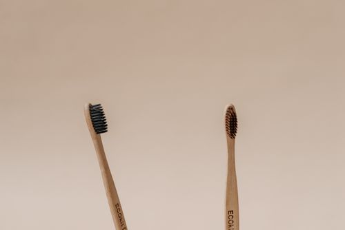 Free Two bamboo toothbrushes with natural bristles on a beige background, emphasizing sustainability. Stock Photo