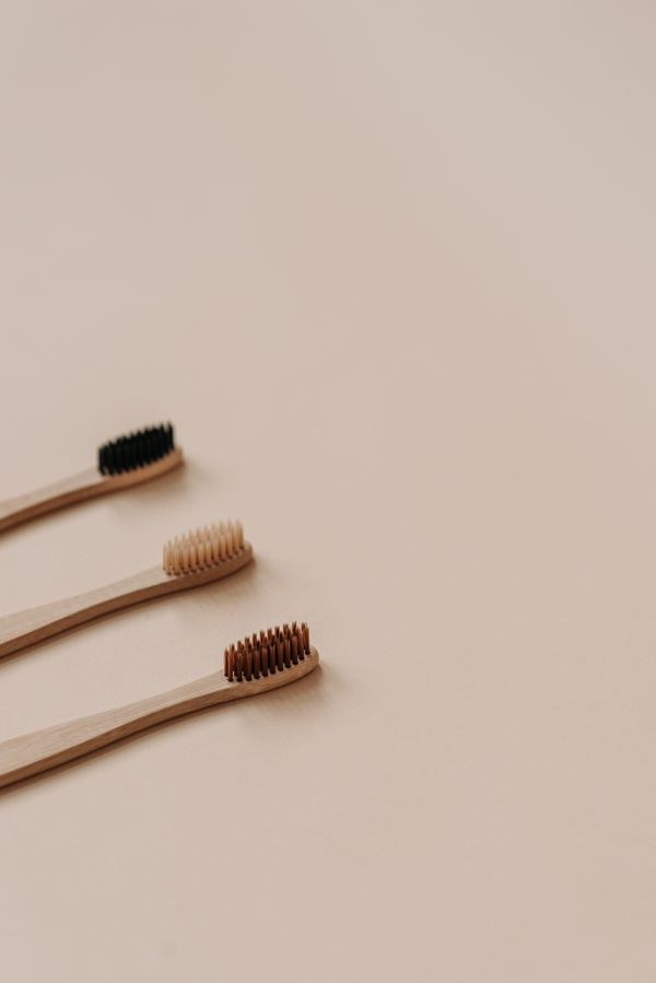 Wooden toothbrushes on a beige surface — photo by Pavel Danilyuk on Pexels
