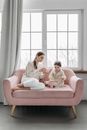 2 Women Sitting on Pink Sofa