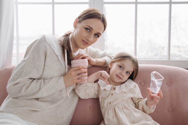 Woman And Child Holding A Disposable Cup And Reusable Mug