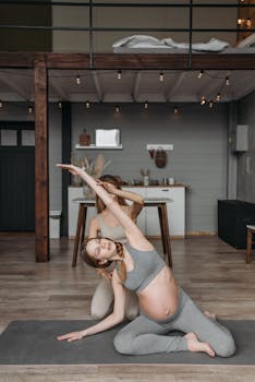 A pregnant woman practicing yoga indoors with guidance from an instructor, promoting a healthy lifestyle and prenatal care.