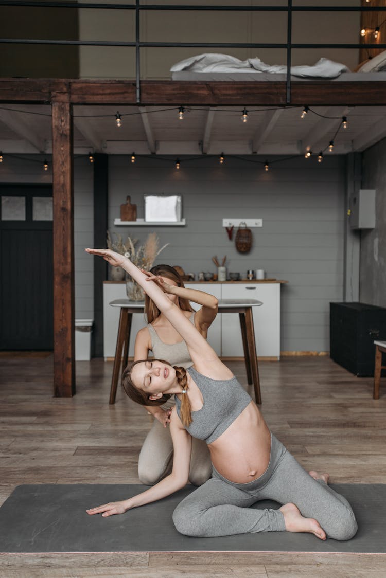 A Pregnant Woman Exercising With Supervision