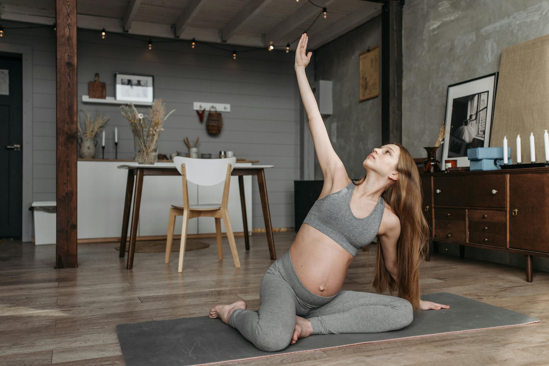 Pregnant woman practicing yoga indoors, promoting wellness and a healthy lifestyle.