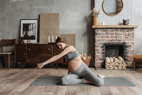 Free Pregnant woman doing yoga at home, focusing on wellness and relaxation. Stock Photo