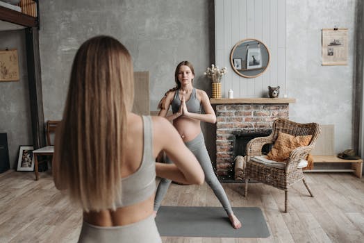 A pregnant woman in activewear holds a yoga pose indoors, promoting wellness and relaxation.