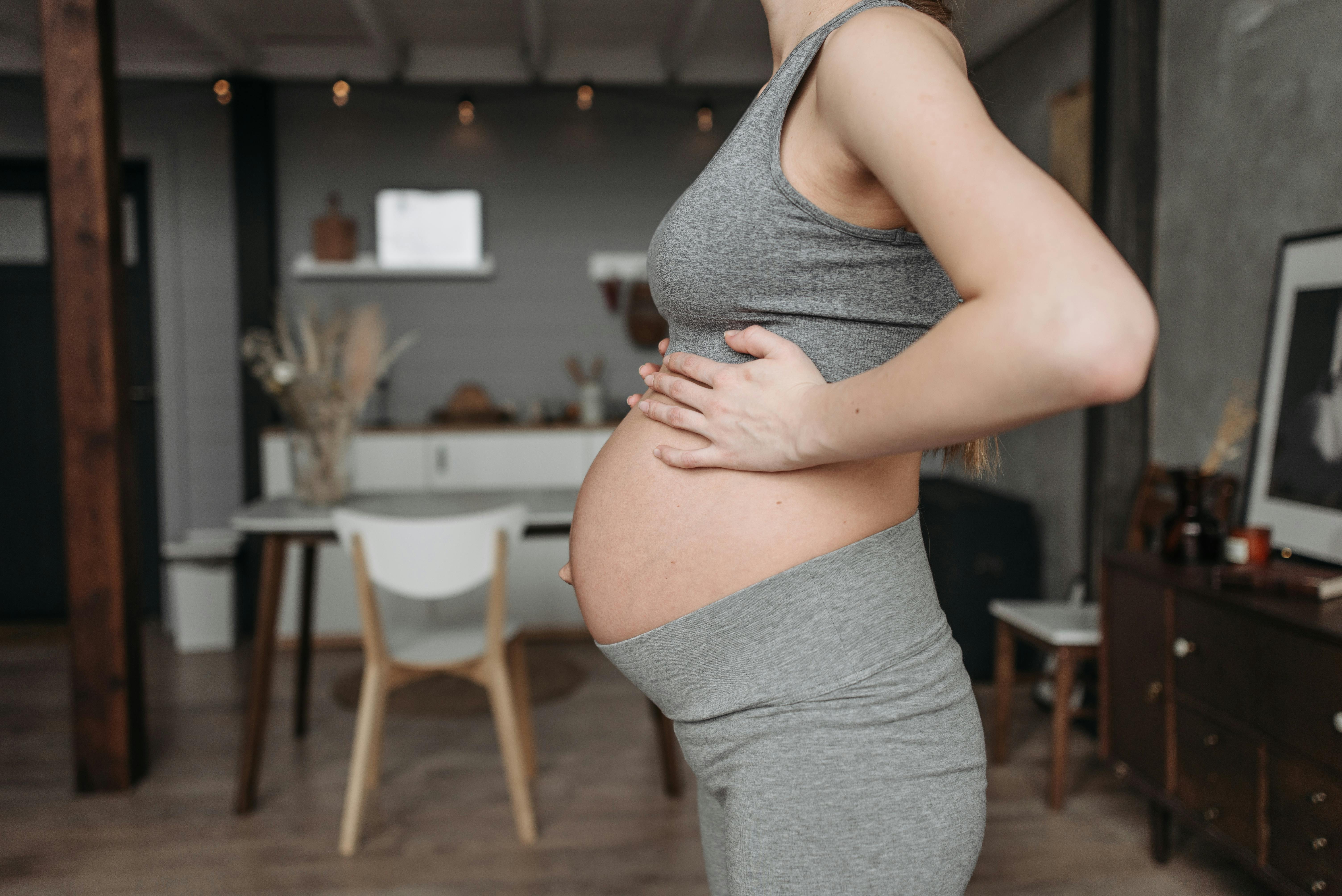 shallow focus photo of a pregnant woman wearing gray activewear