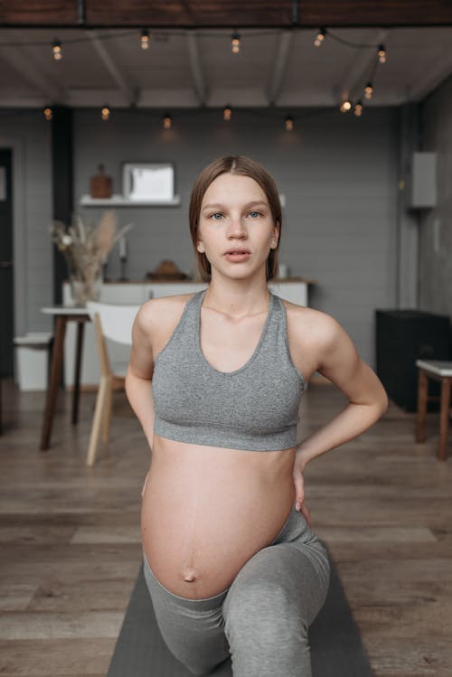 Free A Pregnant Woman in Gray Activewear Exercising at Home
 Stock Photo