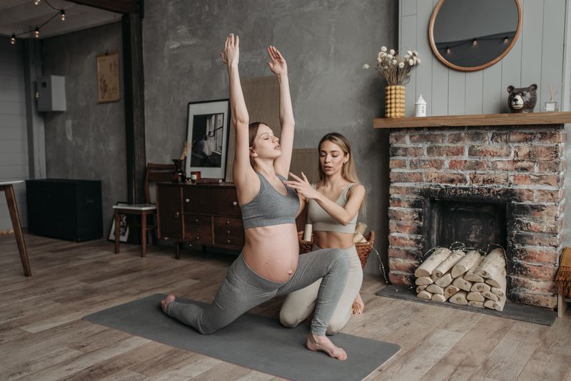 Donna incinta che pratica yoga con trainer