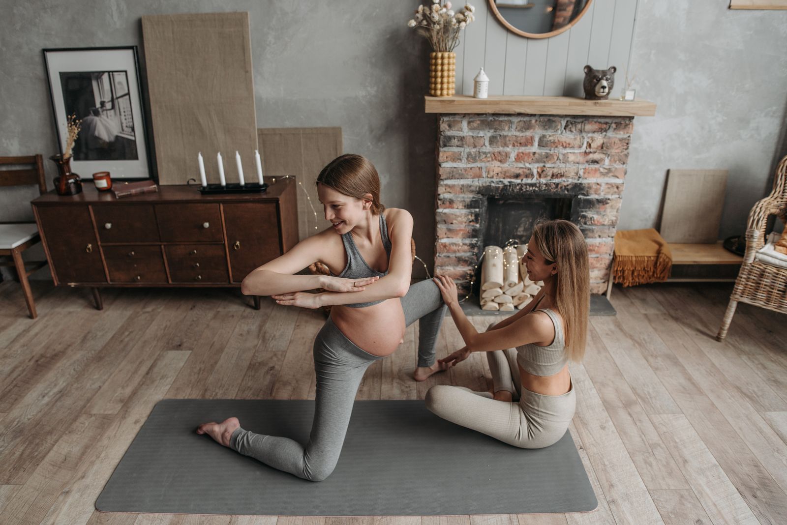 Pregnant woman practicing a gentle yoga pose at home during an online prenatal yoga session