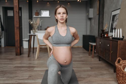 Free Pregnant woman in activewear doing yoga at home, promoting wellness and prenatal fitness. Stock Photo