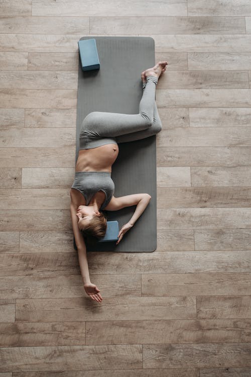 Free A Pregnant Woman Exercising over a Yoga Mat Stock Photo