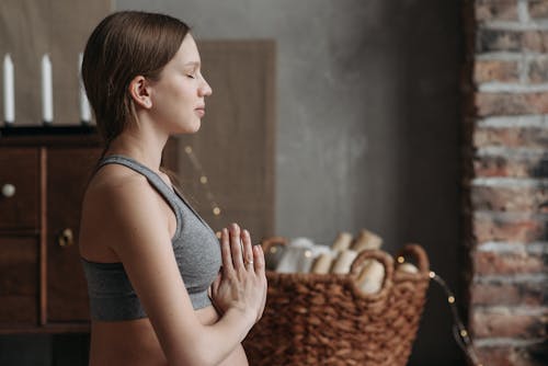 A Woman Wearing Gray Tank Top in Yoga Pose