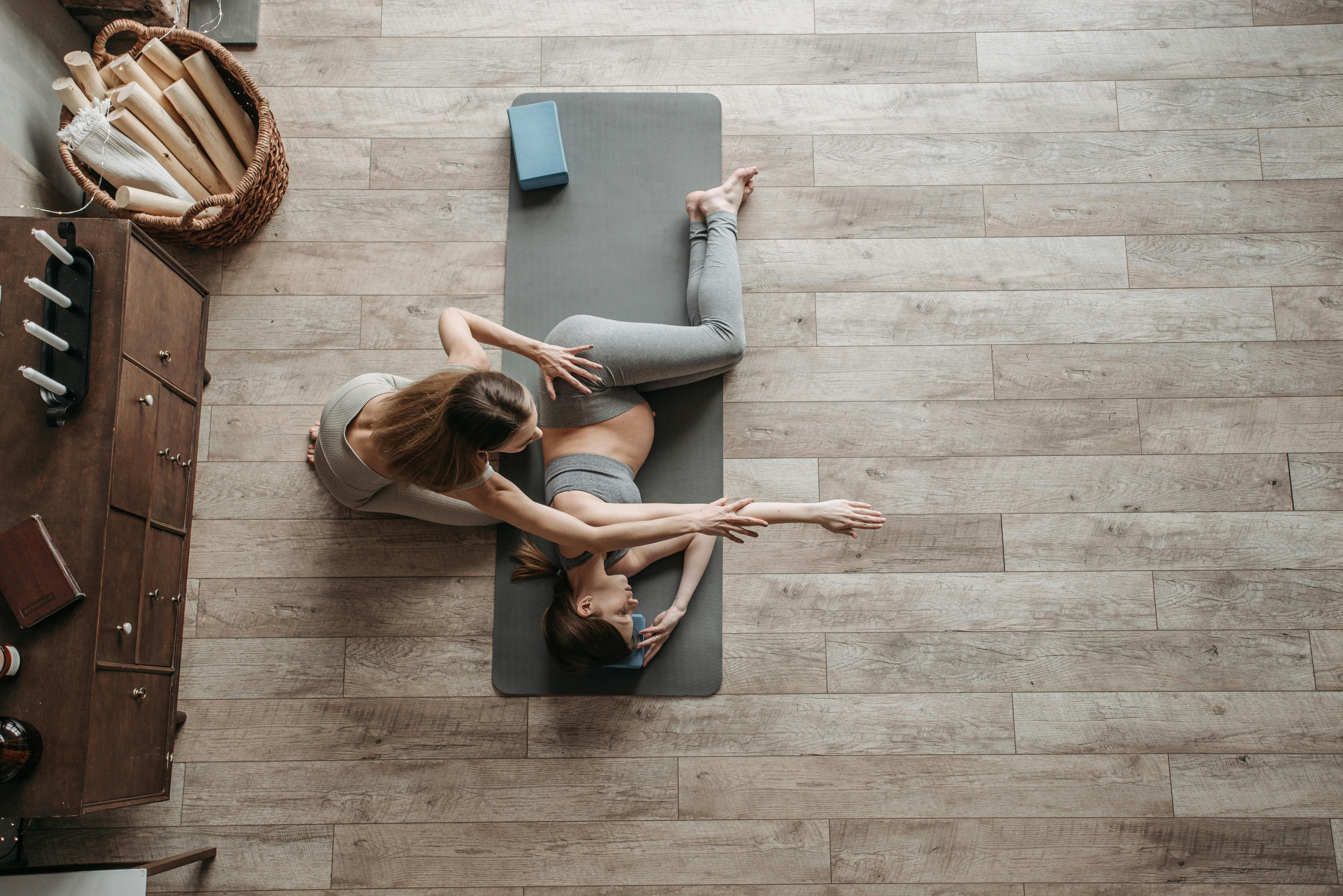 a pregnant woman exercising at home with her personal trainer