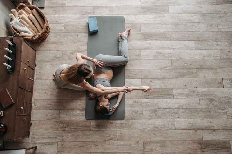 Coach guiding a client through a stretch