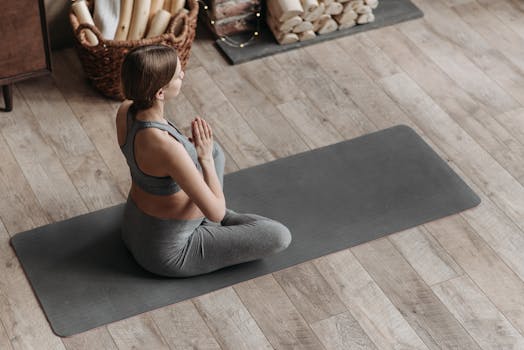 Expectant mother in yoga pose at home, promoting health and balance during pregnancy.