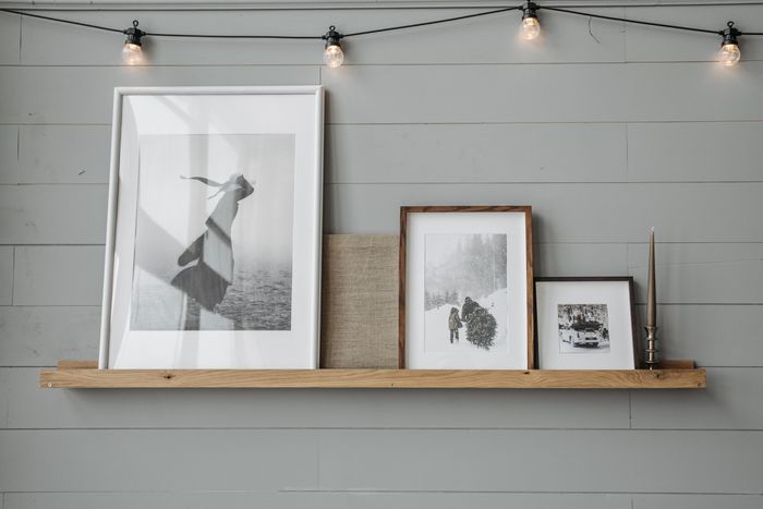 Oak picture ledge holding framed black and white prints, by Pavel Danilyuk on Pexels