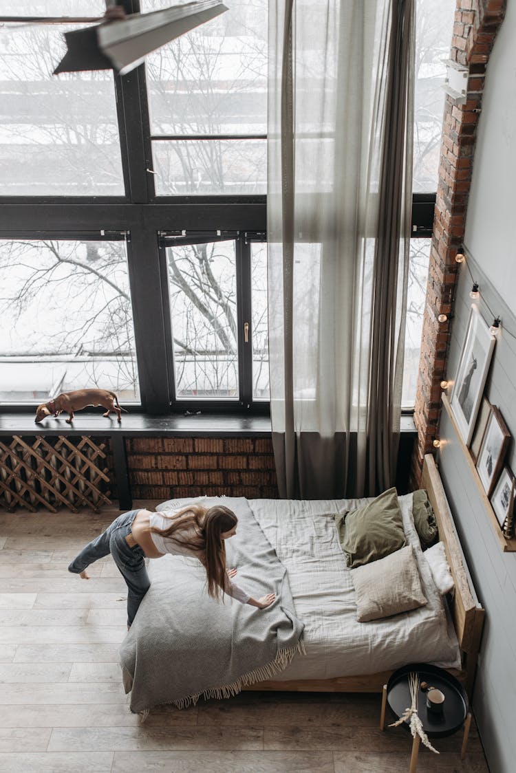 A Woman Fixing The Bed Cover