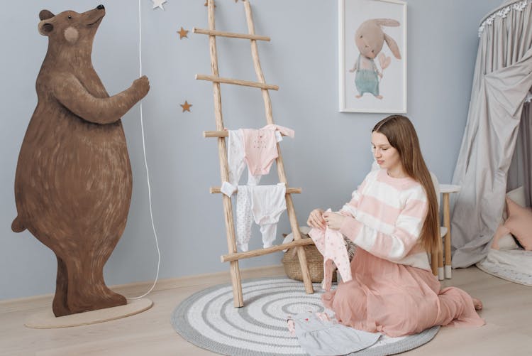 Pregnant Woman Folding Baby Clothes