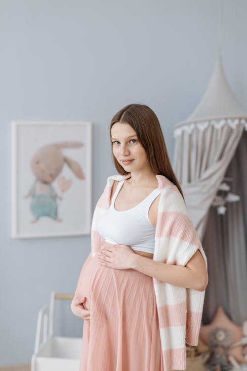 Free An Expectant Mother Touching Her Baby Bump Stock Photo