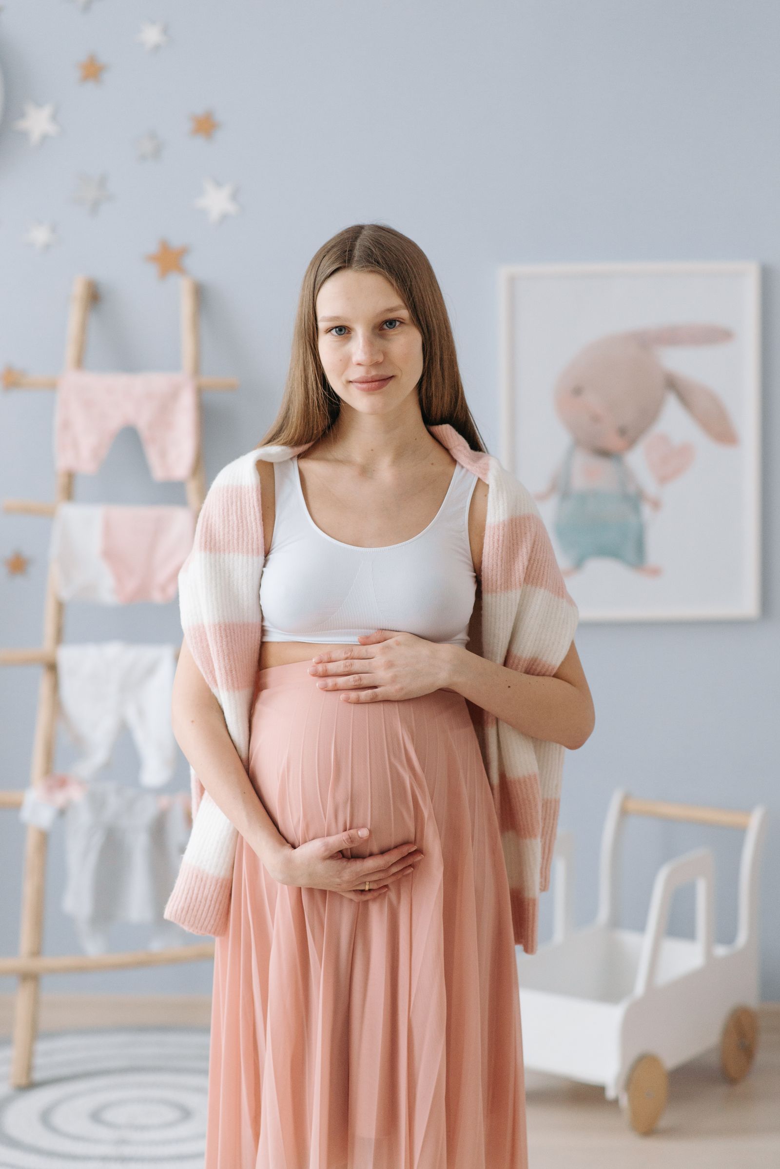 Expectant mother gently embracing her baby bump in a warm peaceful setting