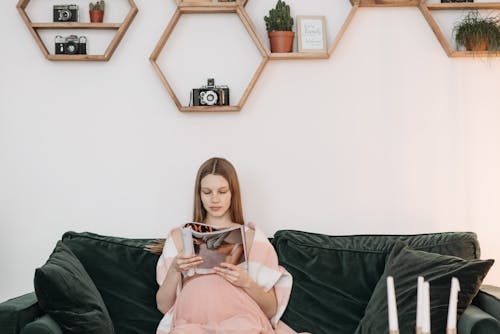 Free Pretty Pregnant Woman Reading a Magazine Stock Photo