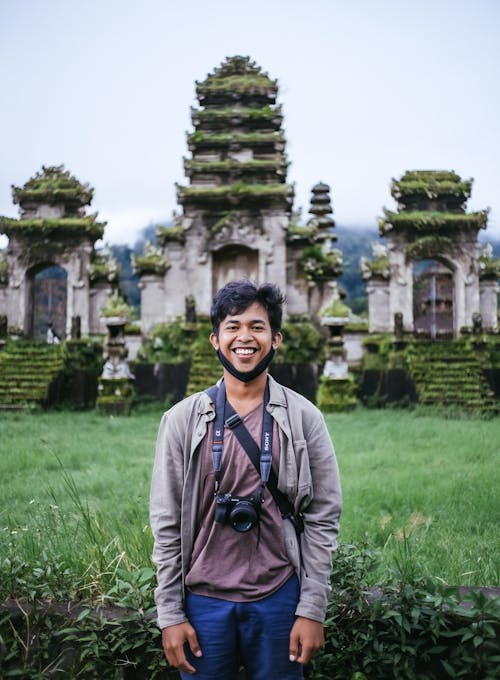 Free Man in Gray Jacket Standing on Green Grass Field Stock Photo