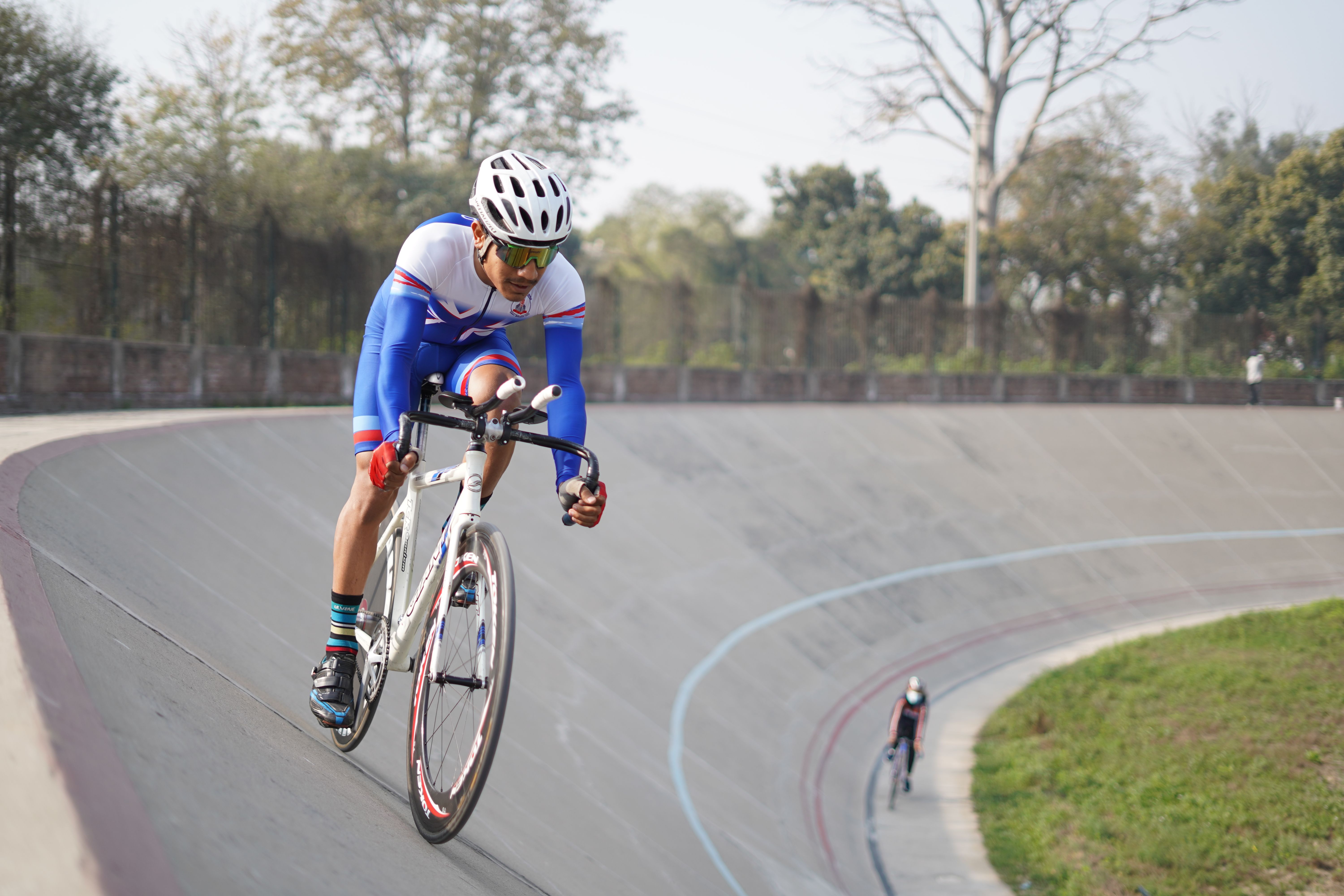 Cyclist in professional gear competing in a velodrome race in Lahore, Pakistan.