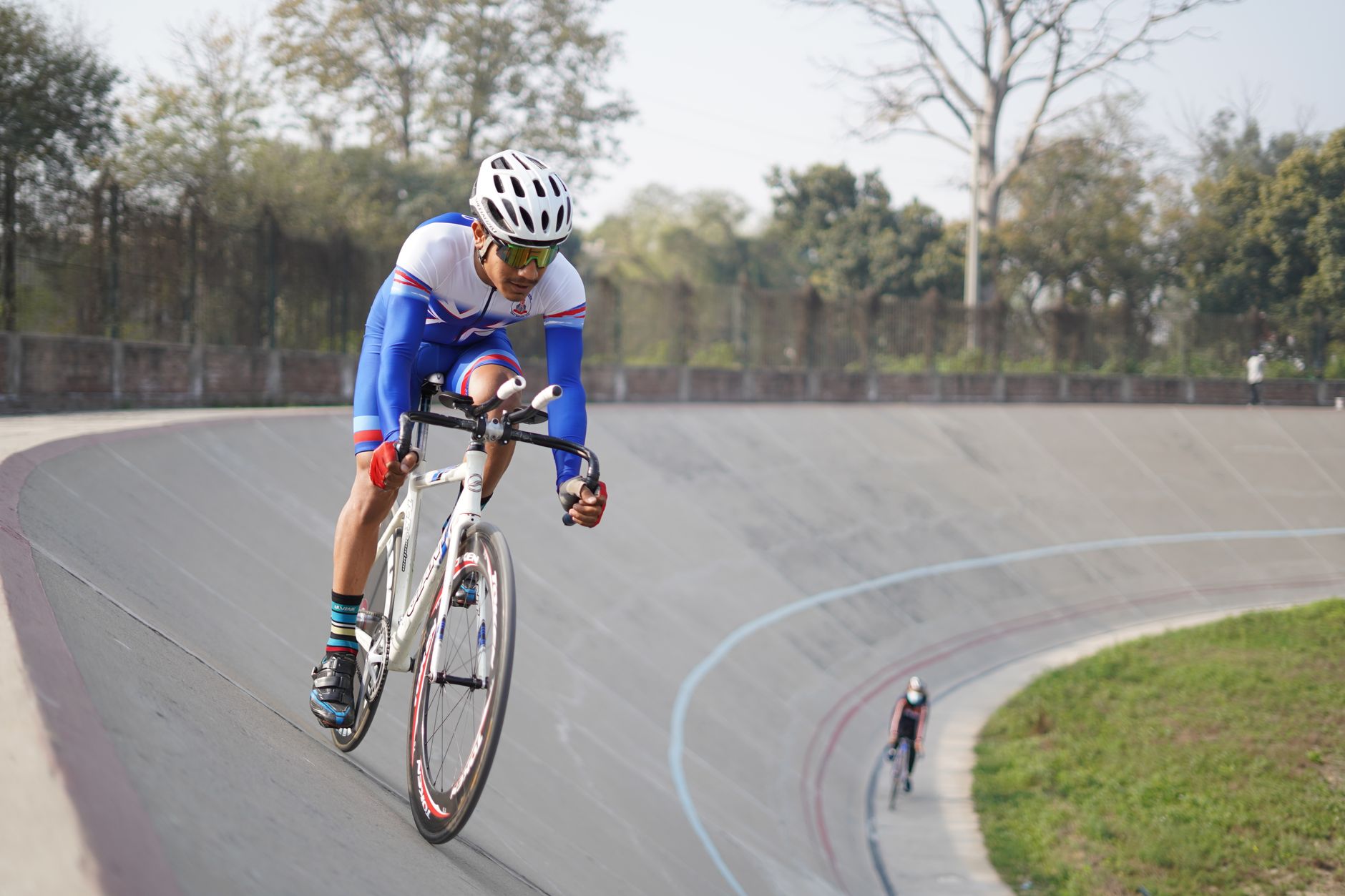 Cyclist in professional gear competing in a velodrome race in Lahore, Pakistan.