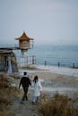 Photo of a Couple Walking Near the Sea