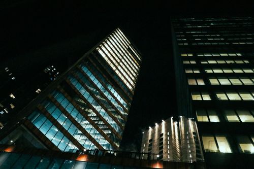 Free Low angle shot of illuminated skyscrapers at night in a cityscape setting. Stock Photo
