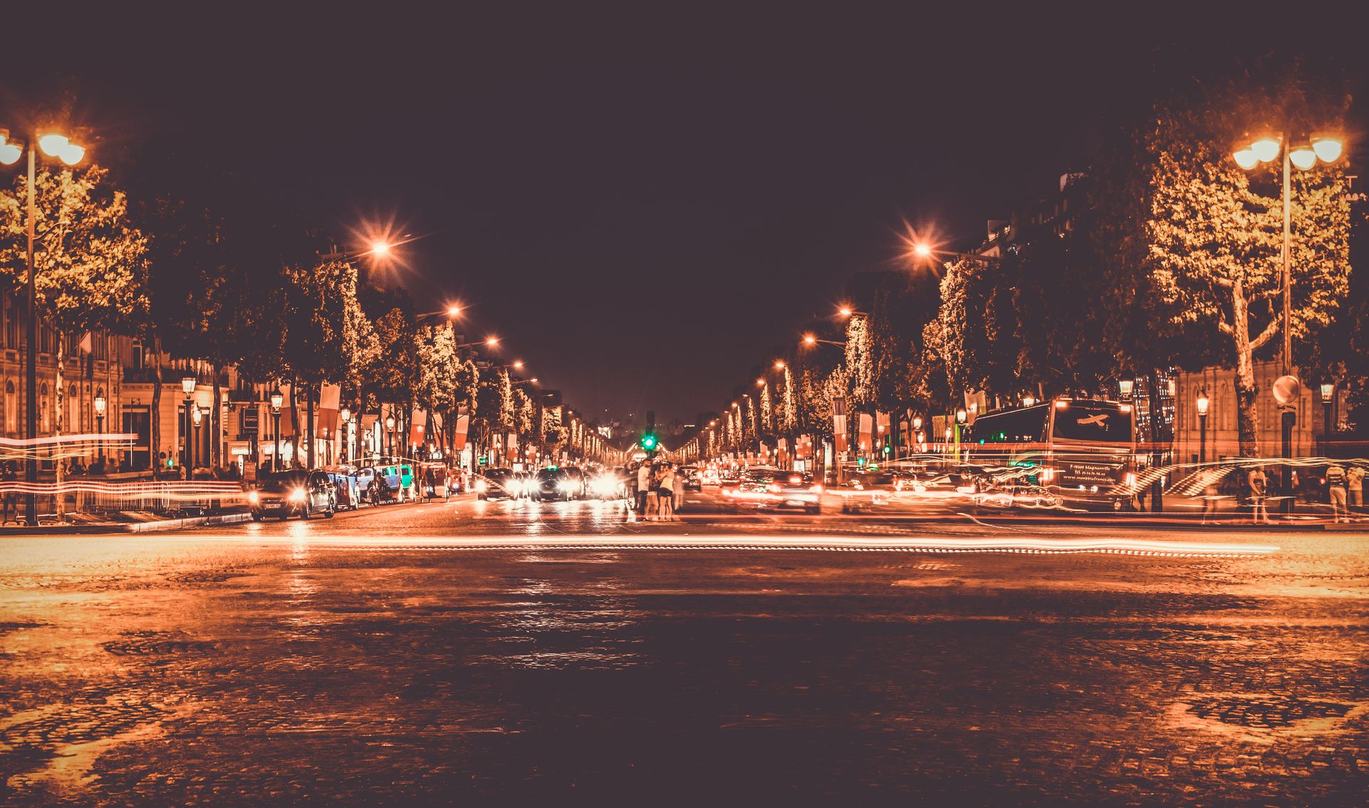 Lighted Street With Cars Passing by during Nighttime