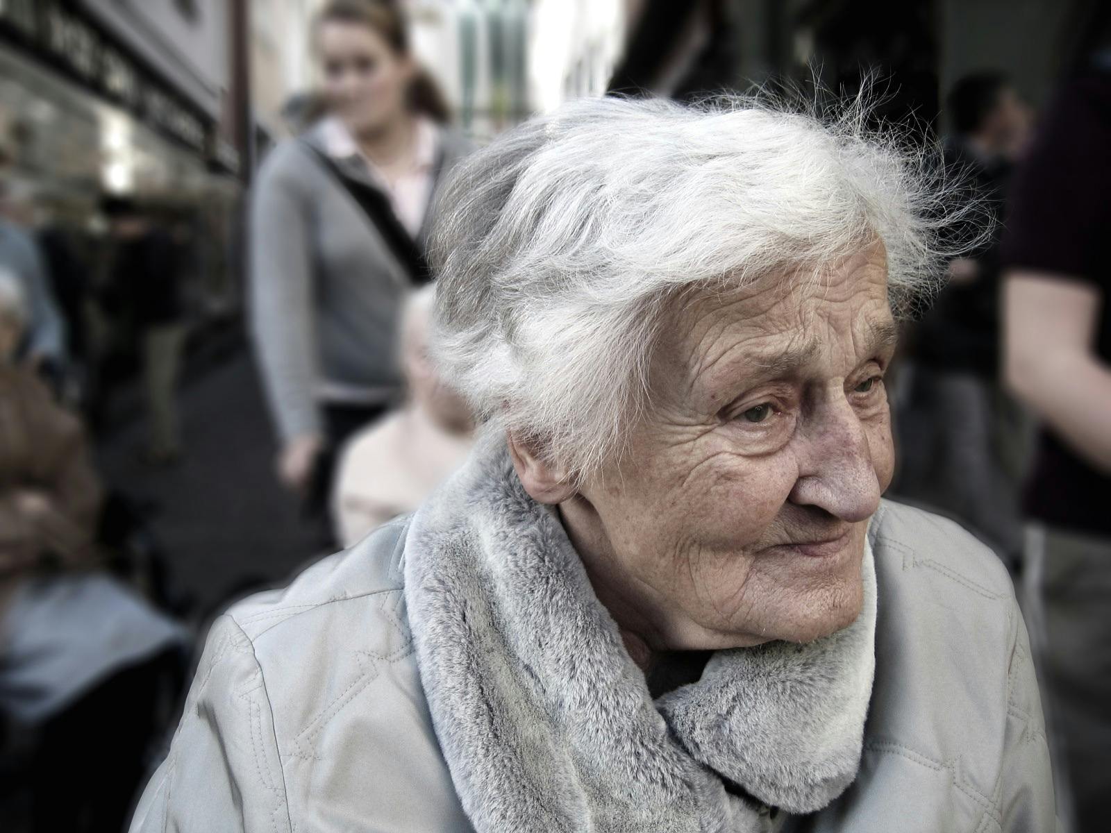 An elderly woman in the midst of people | Photo: Pexels