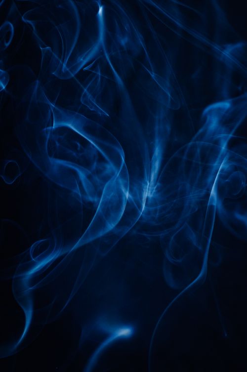 Free Mystical blue smoke swirls elegantly on a dark backdrop, creating a dreamy abstract scene. Stock Photo