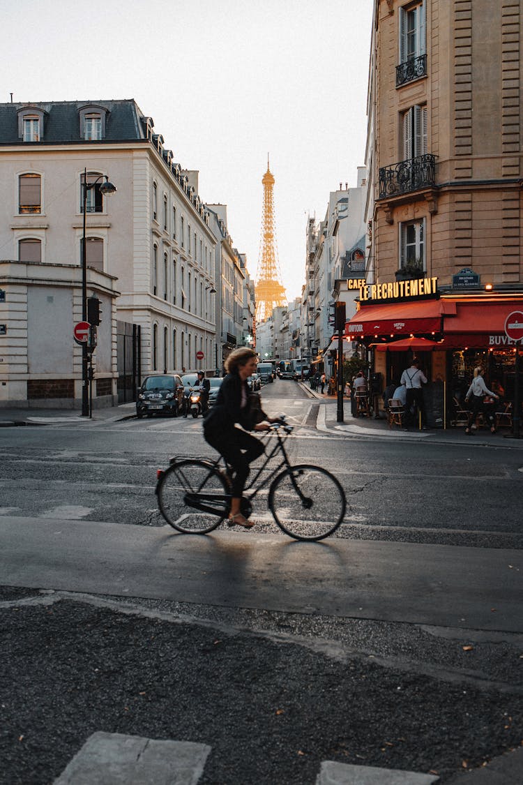 

A Woman Riding A Bicycle On The Road