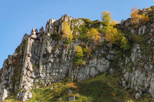 Free Beautiful rocky mountain landscape adorned with autumn foliage under a clear blue sky. Stock Photo