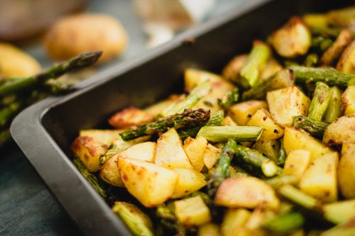 Free Close-up shot of roasted asparagus and potatoes in a baking tray, perfect for vegan meals. Stock Photo