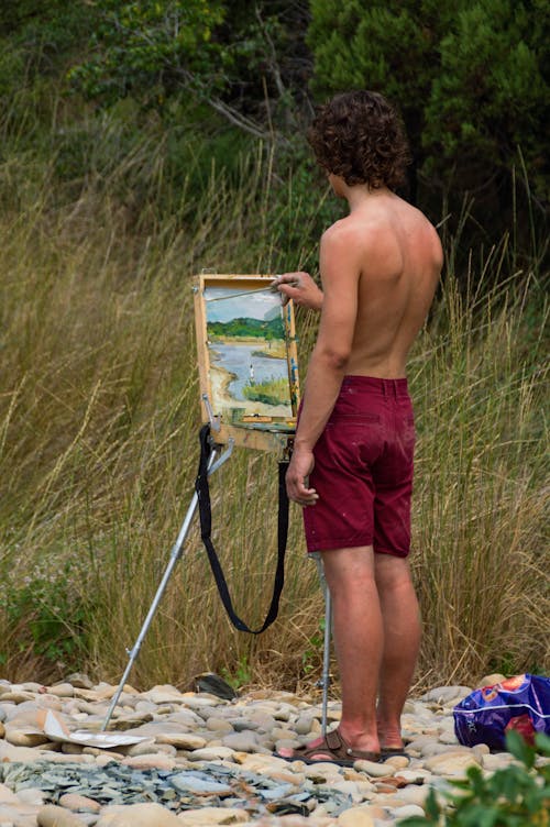 Photo of a Shirtless Man Painting