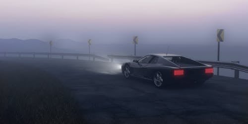 Black Coupe Parked on Concrete Road Near Body of Water