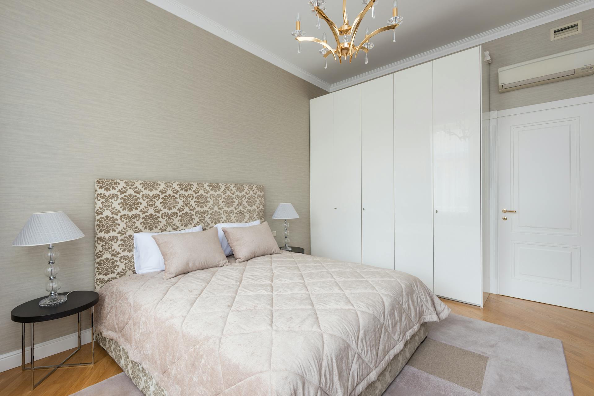 Spacious bedroom featuring a modern design with a chandelier and ample storage space.