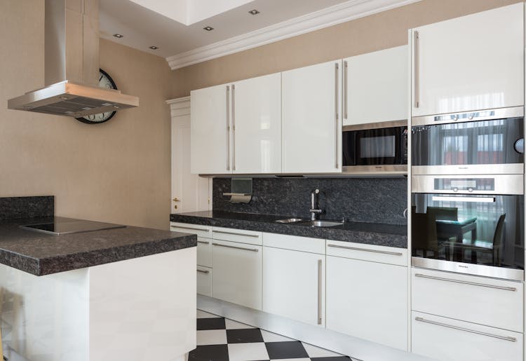 Modern Kitchen With Glossy White Furniture And Marble Counter