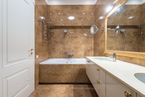 Bathroom interior with bathtub and sinks under mirror