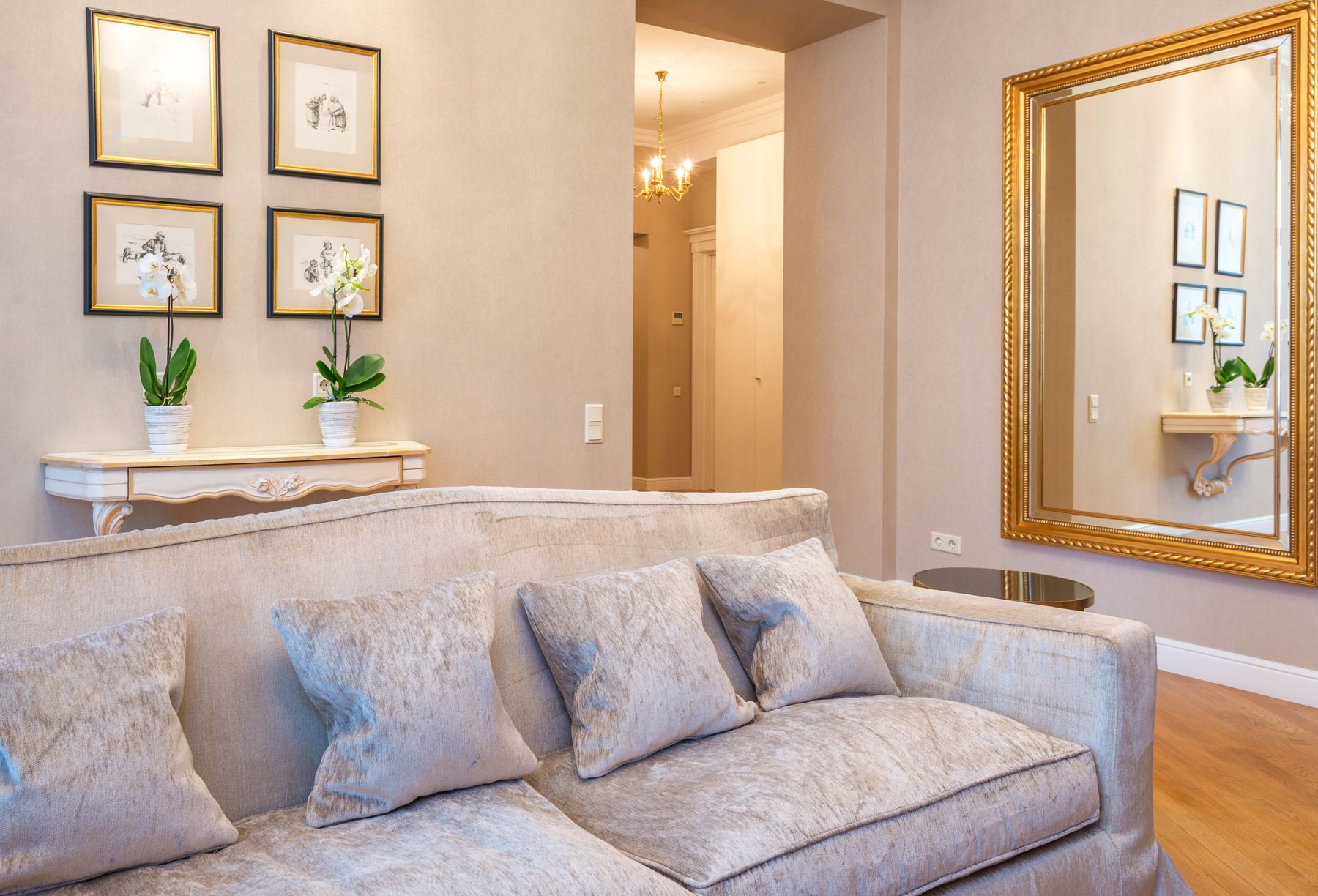 Large wall mirror reflecting a bright apartment living area