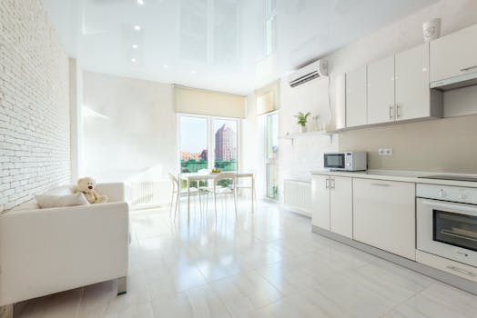 Spacious and contemporary kitchen with white furnishings and natural light.