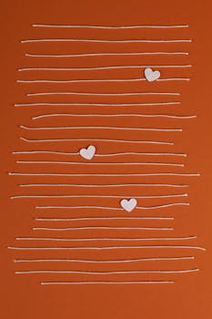 Simple and modern design featuring hearts and lines on an orange backdrop, perfect for wallpaper.