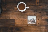 White Ceramic Mug With Coffee Beside Photo of Two Mountain Bikes