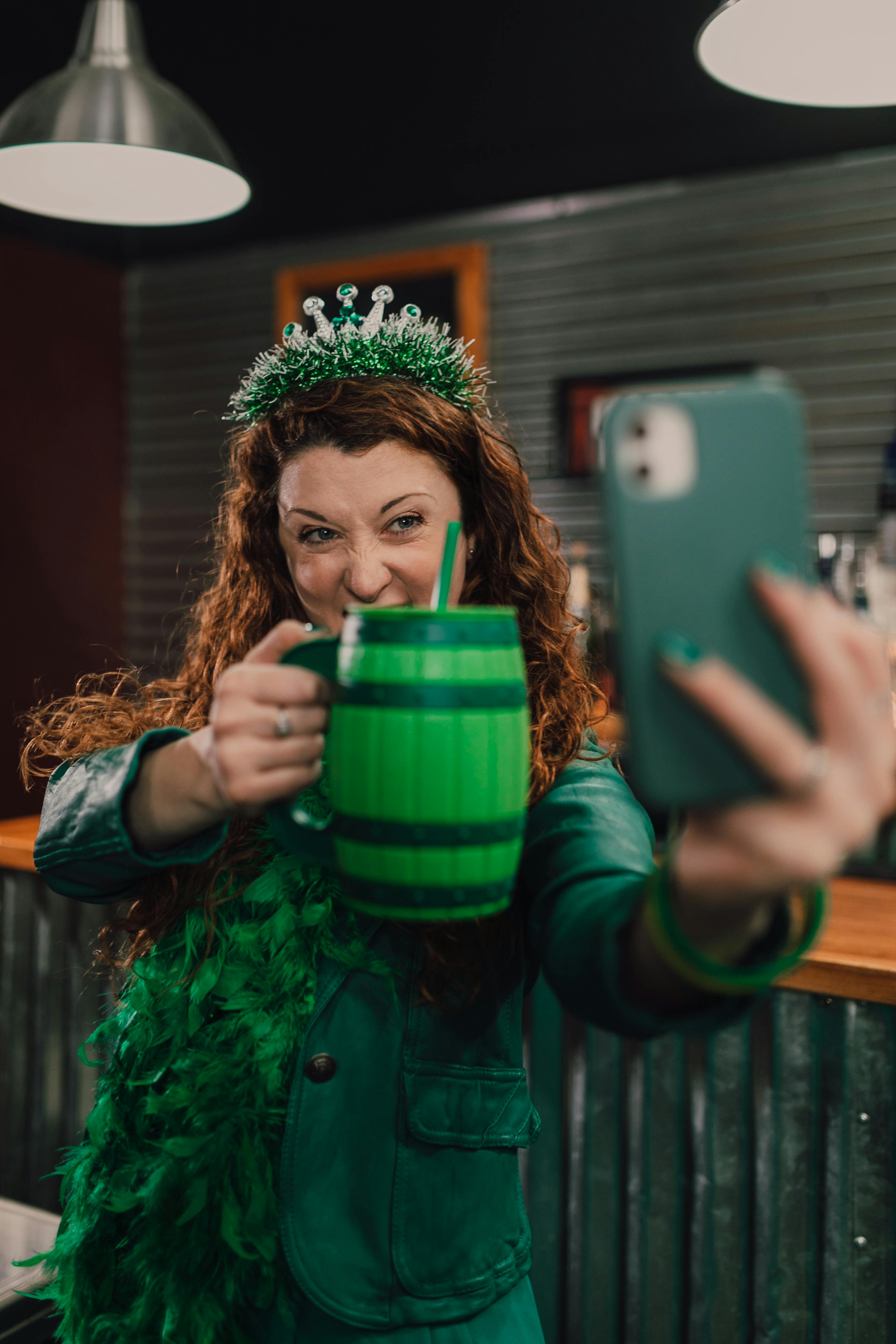 a woman taking a selfie holding a cup of drink