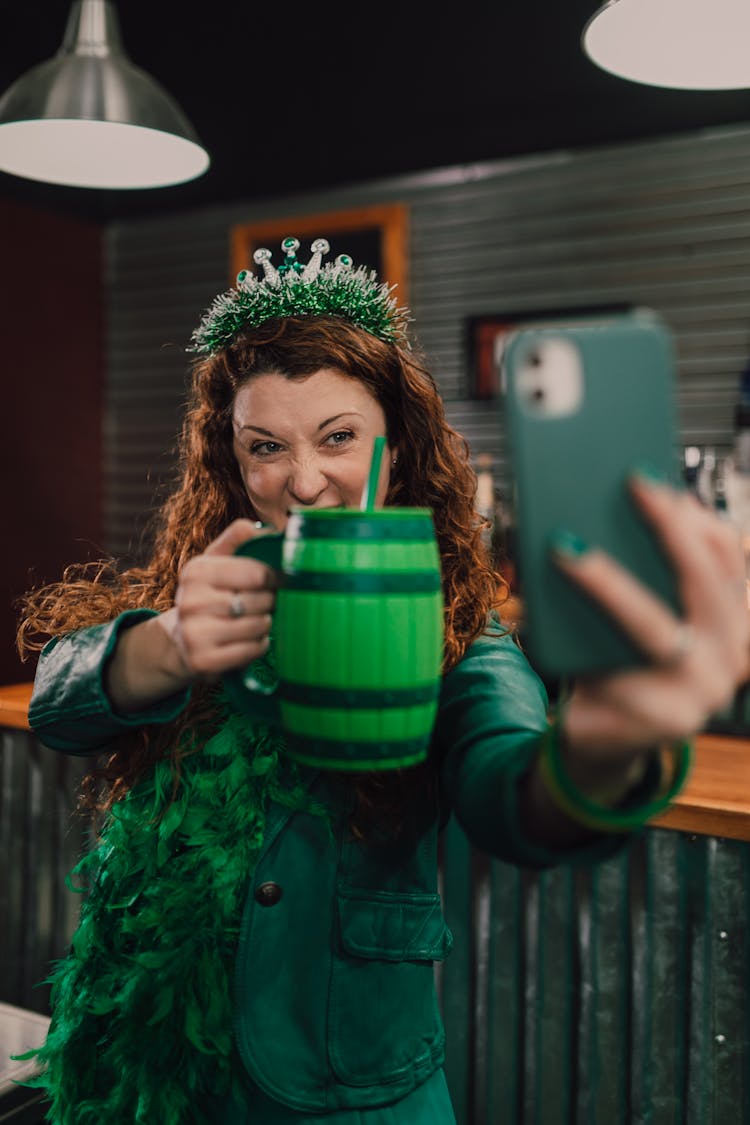 A Woman Taking A Selfie Holding A Cup Of Drink